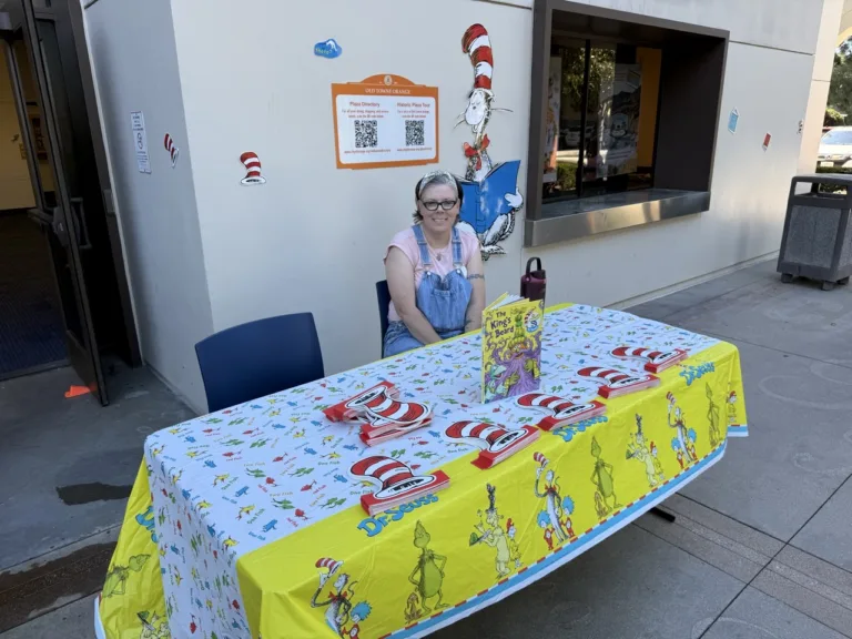 Volunteers at the Dr. Seuss Story Walk check-in table at the Orange Public Library