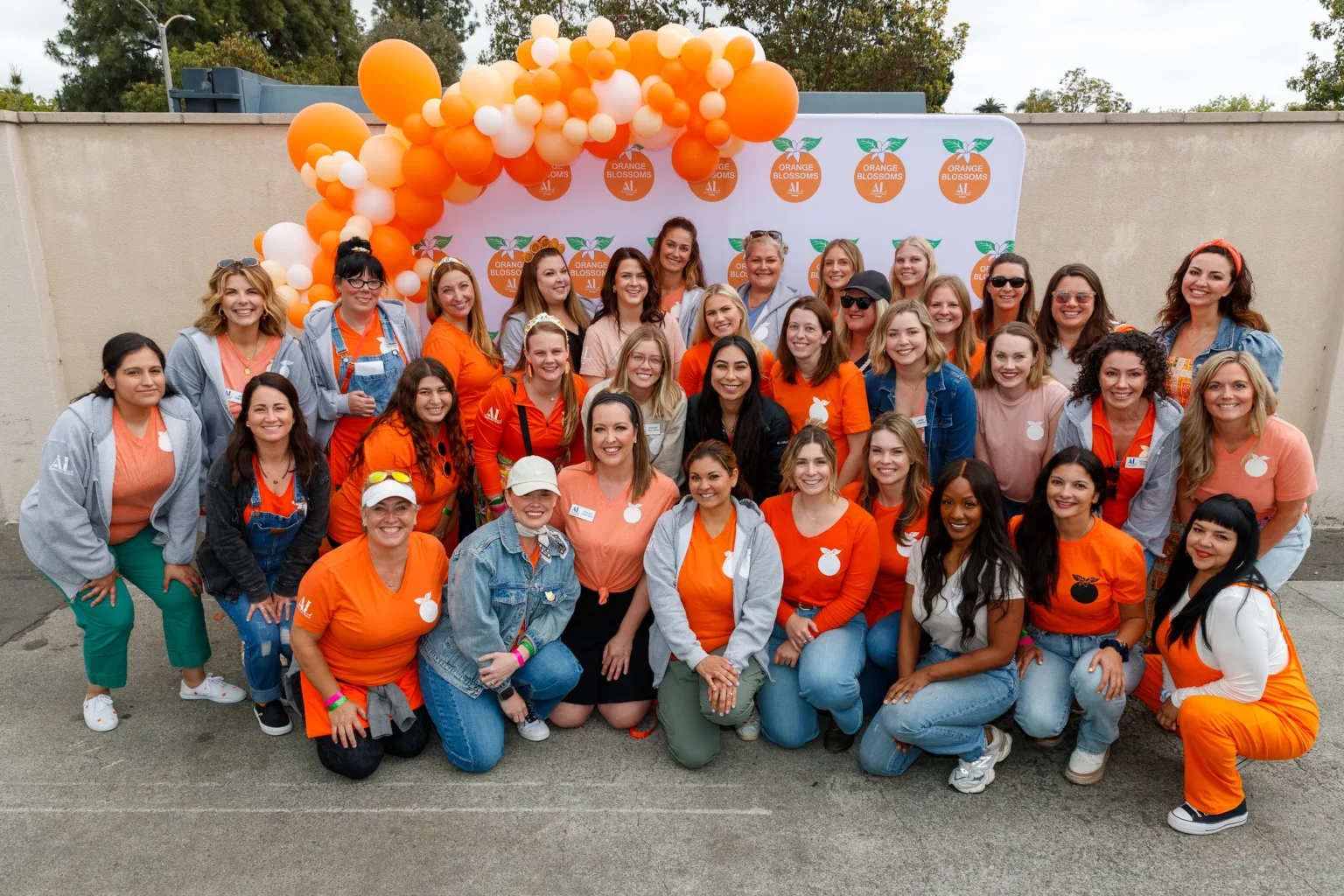 Orange Blossoms Auxiliary members posing together in front of an orange balloon arch