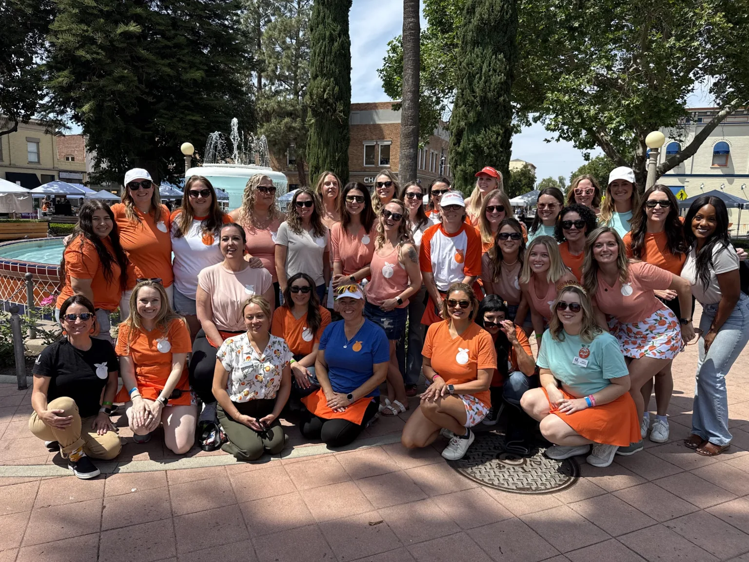 Orange Blossoms volunteers in orange shirts gathered for a group photo in Old Towne Orange, California